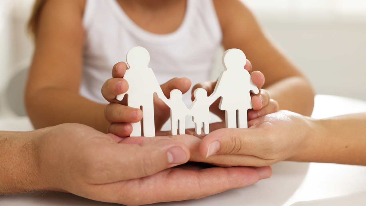 Parents and child with figures of family at white table, closeup
